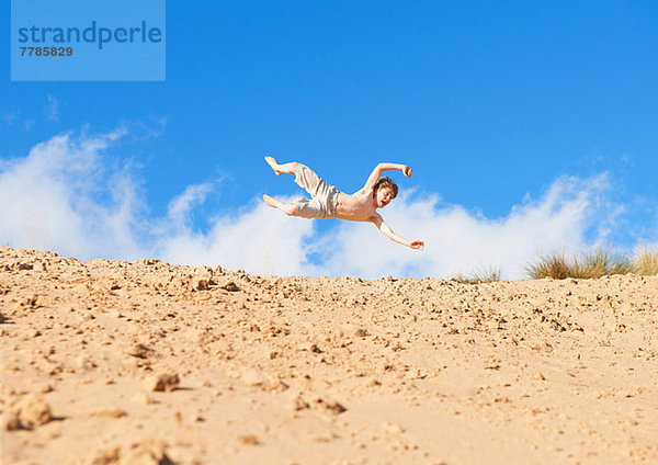 Junge springt am Strand