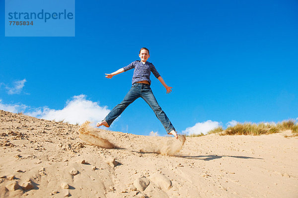 Teenager-Mädchen springt auf Sand