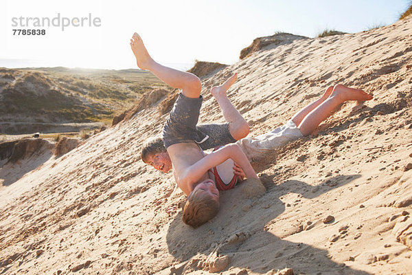 Zwei Jungen rollen am Strand