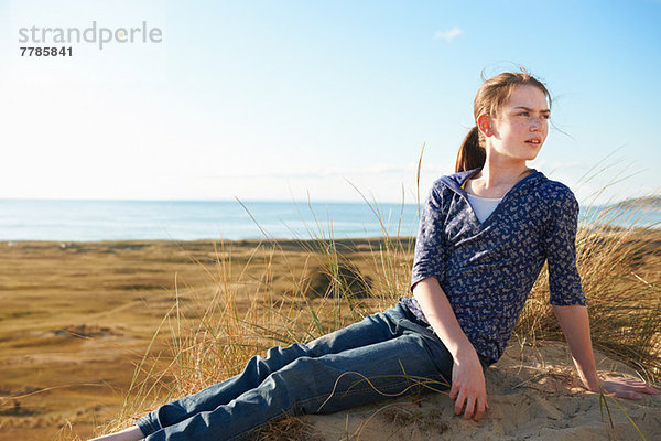 Teenager-Mädchen am Strand sitzend