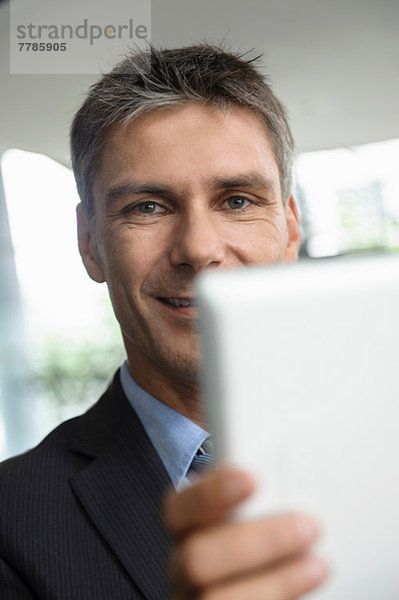 Reife Geschäftsleute mit digitalem Tablett