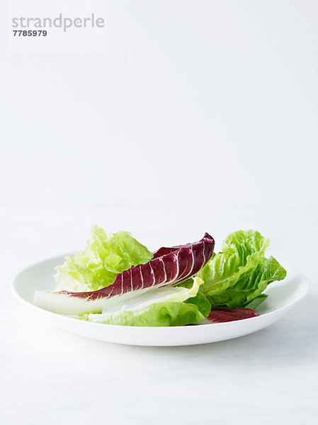 Gemischte Salatblätter auf weißem Teller