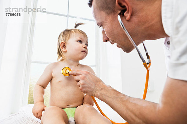 Arzt untersucht Kleinkind Mädchen mit Stethoskop