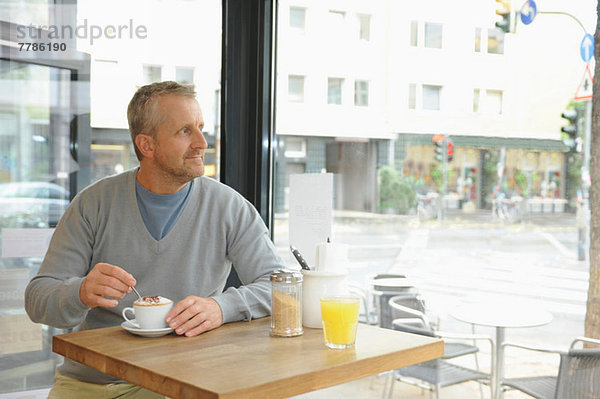 Erwachsener Mann im Coffee-Shop sitzend
