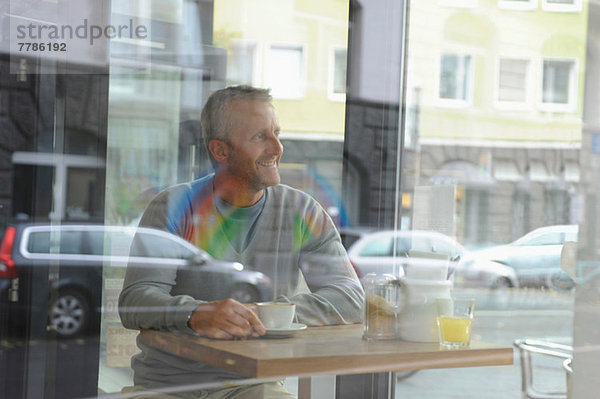Erwachsener Mann im Coffee-Shop sitzend