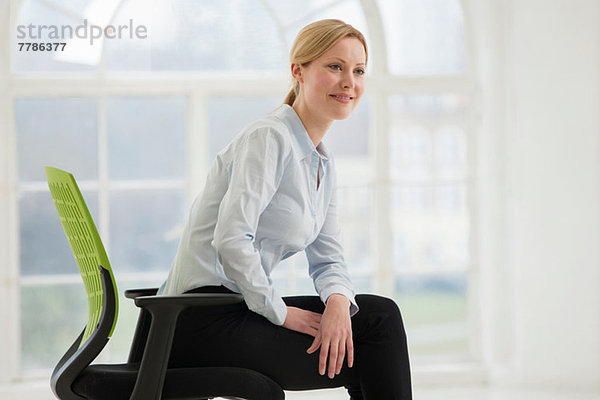Geschäftsfrau auf Bürostuhl sitzend