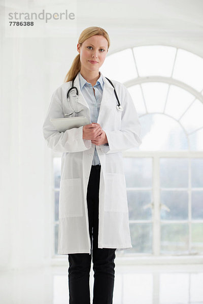 Porträt einer Ärztin mit Stethoskop und digitalem Tablett