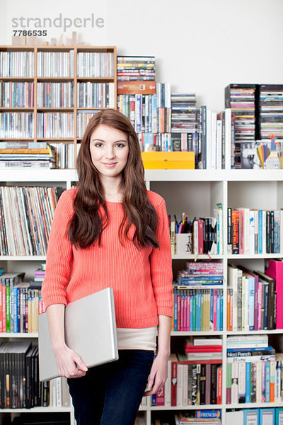Portrait der Studentin vor dem Bücherregal