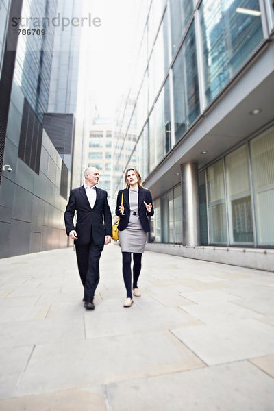 Geschäftsmann und Geschäftsfrau beim Vorbeigehen an Bürogebäuden