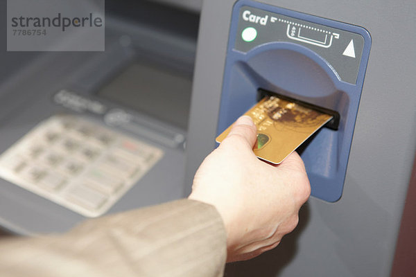 Frau Einsetzen Kreditkarte in Geldautomat