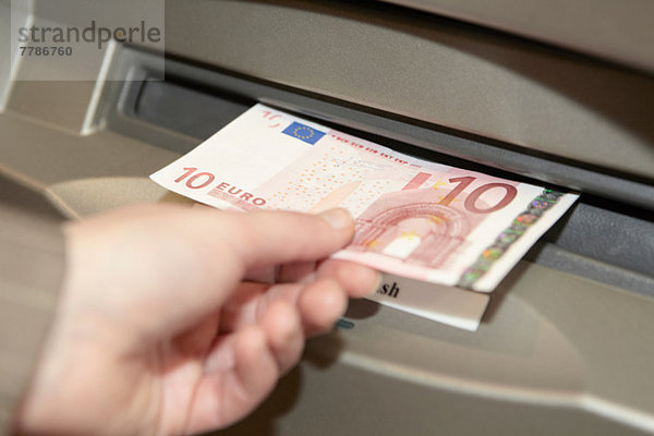 Frau zieht zehn Euro-Banknote aus
