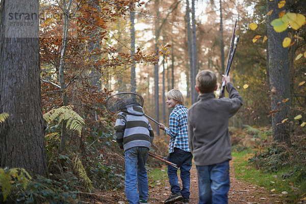 Jungen beim Waldspaziergang mit Angelausrüstung