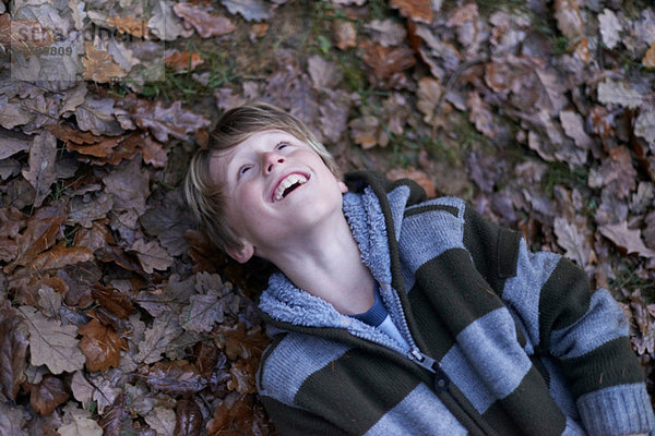 Junge auf dem Rücken auf dem Waldboden liegend