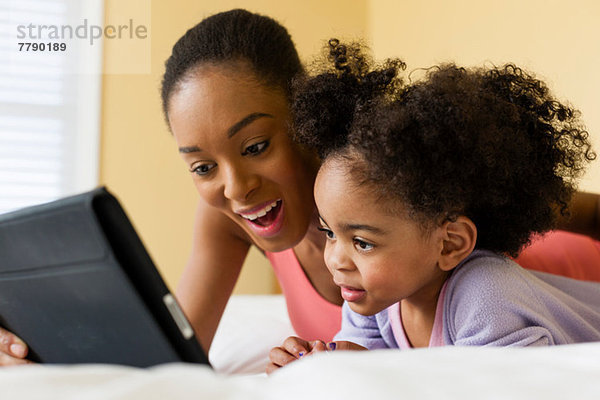 Mutter und Tochter mit digitaler Tablette