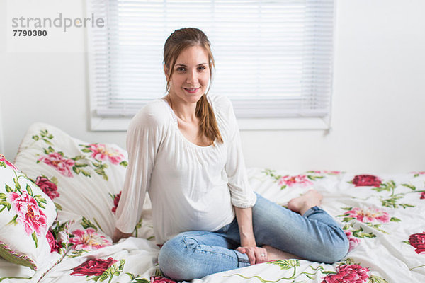Porträt einer schwangeren Frau auf dem Bett