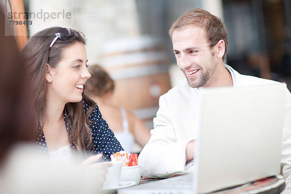 Junge Frau und junger Mann mit Laptop im Café