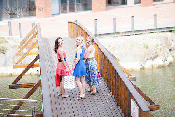 Drei junge Frauen gehen über die Brücke
