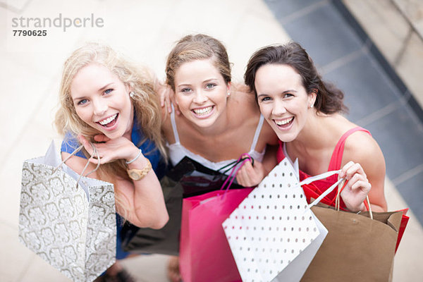 Drei junge Frauen mit ihren Einkaufstaschen
