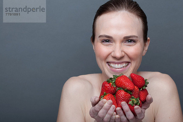 Junge Frau mit Erdbeeren in der Hand