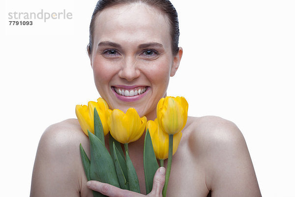 Junge Frau mit Blume im Haar und Händen im Gesicht