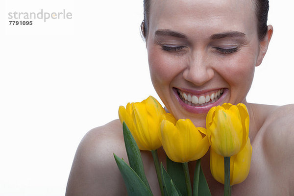 Junge Frau mit Blume im Haar und Händen im Gesicht