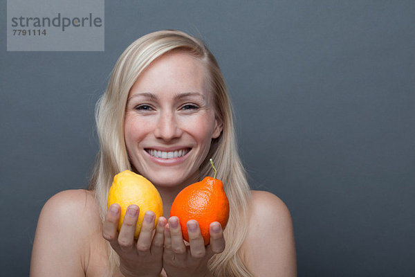 Junge Frau mit Orange und Zitrone