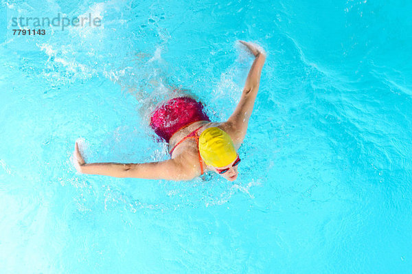 Reife Frau beim Schmetterlingsschwimmen im Schwimmbad