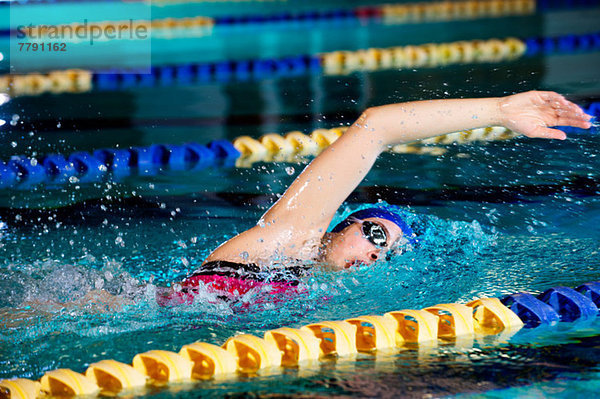 Junge Frau beim Frontkriechen im Schwimmbad