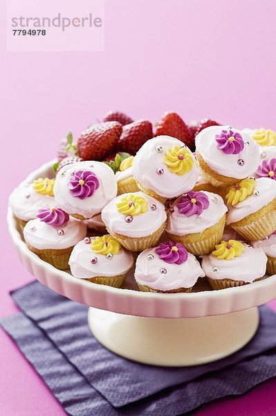 Viele Mini-Cupcakes   mit Zuckerblumen verziert  auf Kuchenständer