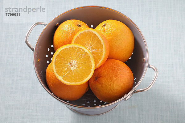 Studioaufnahme  Orange  Orangen  Apfelsine  Apfelsinen  über  Hintergrund  blau  Ansicht  Küchensieb