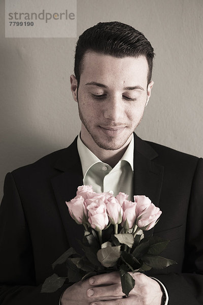 Studioaufnahme  Blumenstrauß  Strauß  Portrait  Mann  sehen  halten  pink  Rose  jung