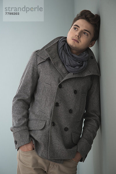 Portrait Mann Schal Jacke Hintergrund jung Kleidung schießen Studioaufnahme grau