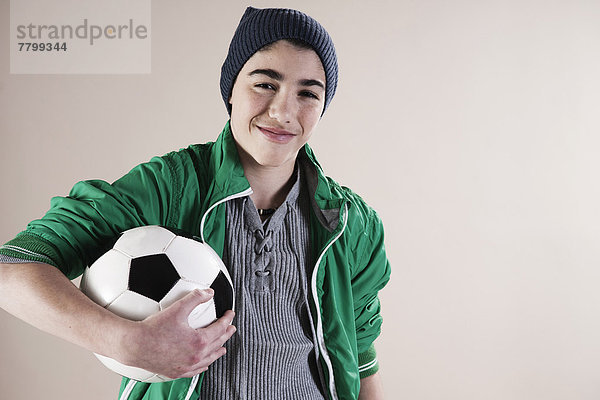 Portrait  Junge - Person  halten  Fußball  Studioaufnahme  Ball Spielzeug