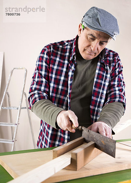 Man Cutting Lumber  Woodworking Project  in Studio