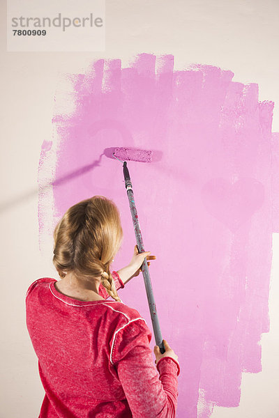 Frau  Wand  streichen  streicht  streichend  anstreichen  anstreichend  pink  jung  schießen  Studioaufnahme