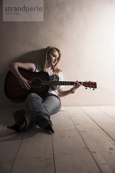 sitzend  Frau  Boden  Fußboden  Fußböden  Spiel  Gitarre  jung  Studioaufnahme