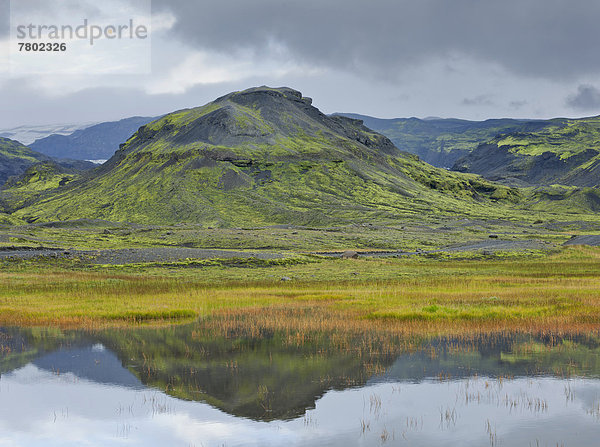 Berg spiegelt sich in einem kleinen See nahe Sölheimajökulsvegur