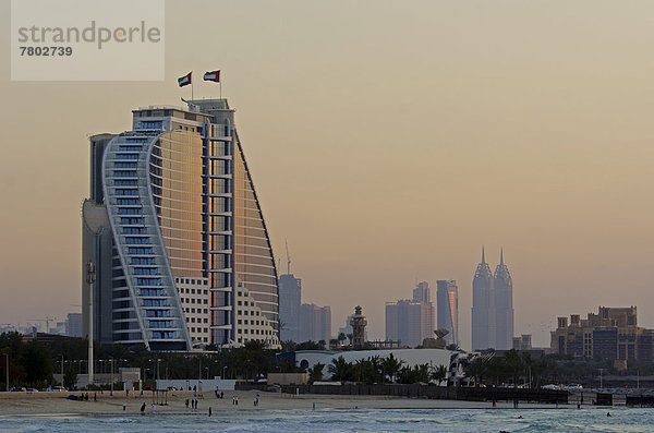 Das beleuchtete Jumeirah Beach Hotel am Jumeirah-Strand in der Abenddämmerung