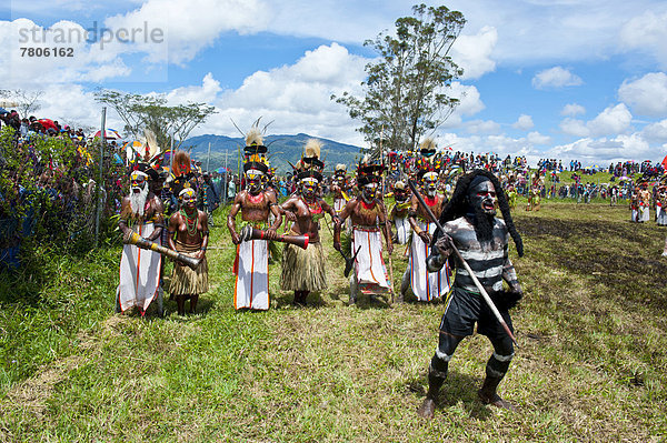 Bunt geschmückte und bemalte Mitglieder eines Volksstamms beim traditionellen Sing-sing