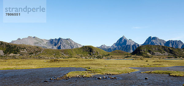 Grüne Weidelandschaft vor schroffen Bergen