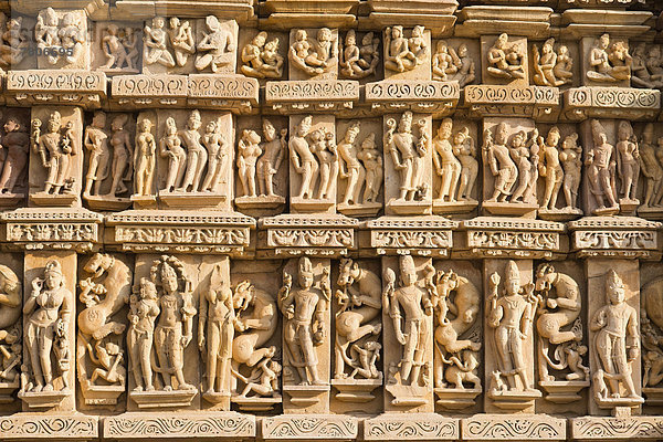 Relief mit Skulpturen von Menschen und Göttern außen am Parshvanath-Tempel  Ostgruppe  Jain-Tempel  Tempelbezirk von Khajuraho  UNESCO-Weltkulturerbe