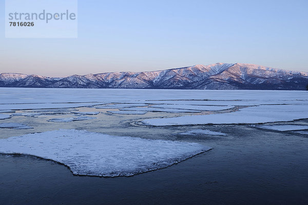 Morgenstimmung am zugefrorenen See Kussharo Lake mit Eisschollen im Vordergrund