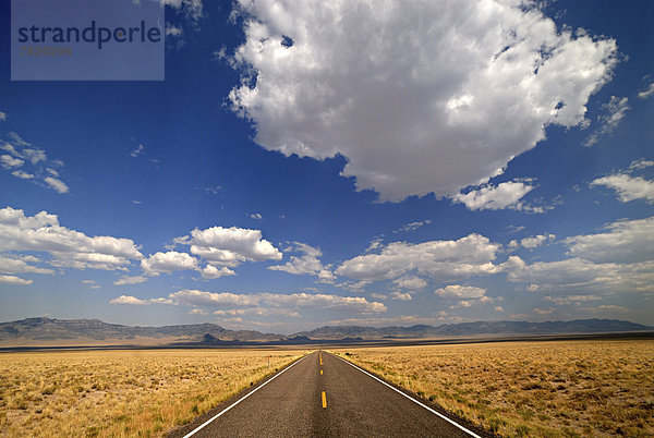 Gerade Straße in weiter Landschaft