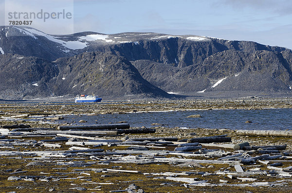 Sicht von Amsterdamøya nach Danskøya  Expeditionskreuzfahrtschiff MS Ocean Nova hinten  Treibholz im Vordergrund