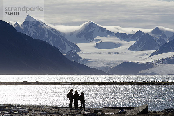 Silhouetten von Expeditionsteilnehmern vor der Berg- und Gletscherkulisse des Smeerenburgbreen