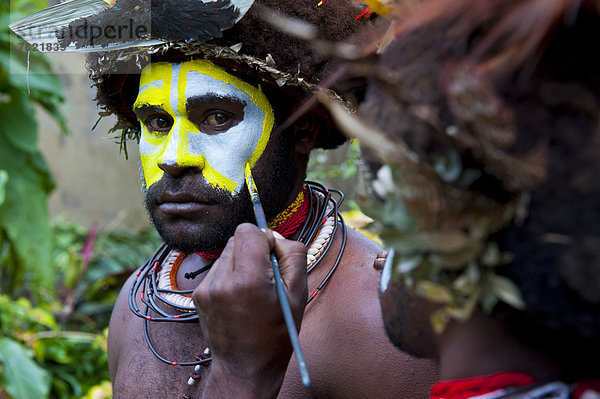 Mann wird geschminkt für das traditionelle Sing Sing im Hochland