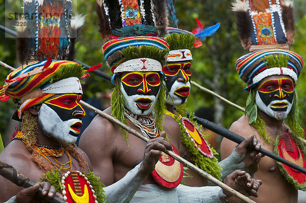 Bunt geschmückte und bemalte Männer feiern das traditionelle Sing Sing im Hochland