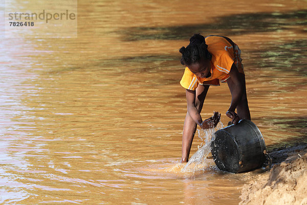 Flussufer  Ufer  Außenaufnahme  Wasser  Sandbank  Küchengerät  waschen  Fluss  Insel  Hausarbeit  Mädchen  Pfanne  Afrika  Madagaskar  freie Natur  Leitungswasser