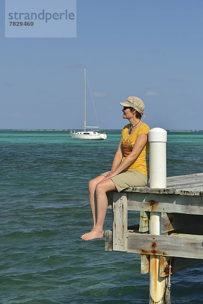 sitzend  Frau  Hut  Meer  Kai  Insel  Karibik  Mittelamerika  Belize