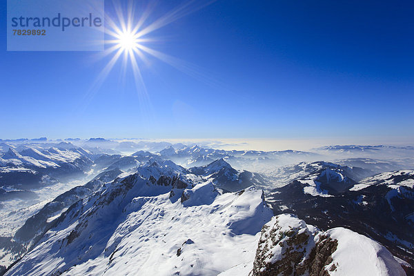 Kälte  Panorama  sternförmig  Europa  Schneedecke  Berg  Winter  Berggipfel  Gipfel  Spitze  Spitzen  Sonnenstrahl  Himmel  Dunst  Schnee  Nebel  Alpen  blau  Ansicht  Sonnenlicht  Westalpen  Bergmassiv  Sonne  schweizerisch  Schweiz